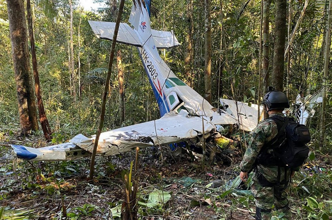 Foto divulgada pelo Exército da Colômbia mostrando um soldado ao lado dos destroços de uma aeronave que caiu na floresta amazônica