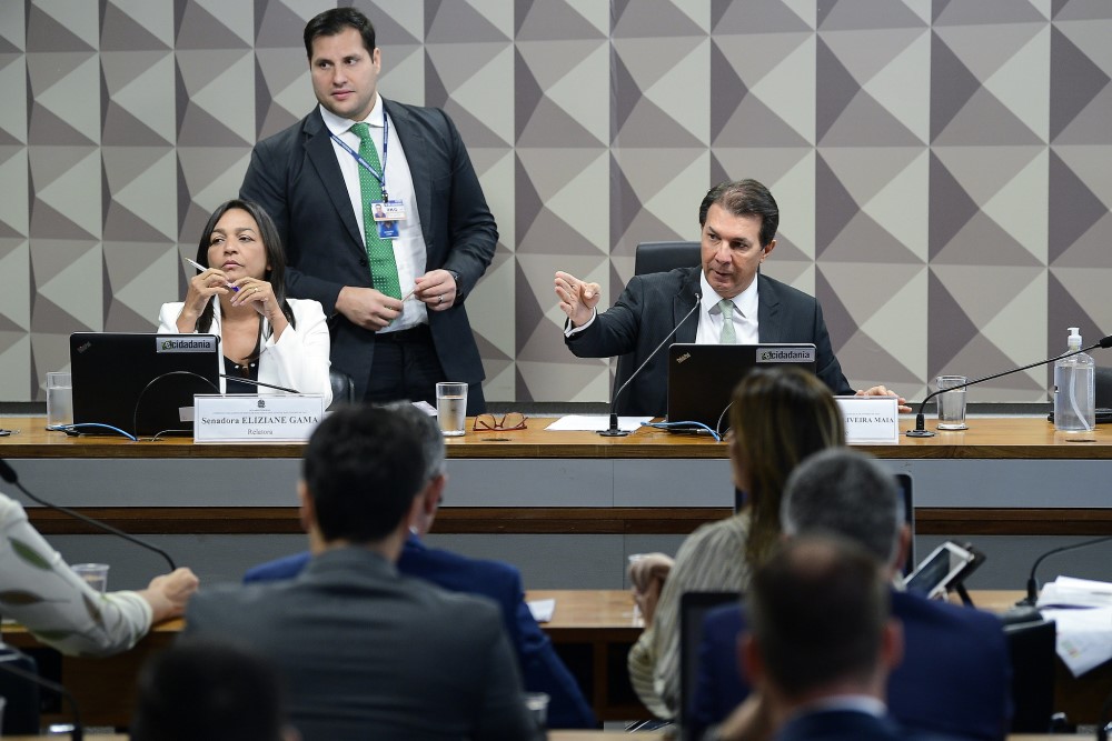 A senadora Elizane Gama e o deputado Arthur Maia, respectivamente relator e presidente da CPMI do 8 de Janeiro, sentados em seus lugares no colegiado