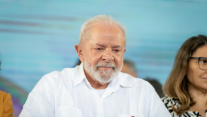 Sentado, de camisa branca, Lula parece abatido ou refelexivo
