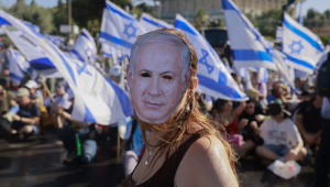 Um manifestante usando uma máscara representando o primeiro-ministro israelense Benjamin Netanyahu participa de uma manifestação para bloquear a entrada do Knesset, o parlamento de Israel