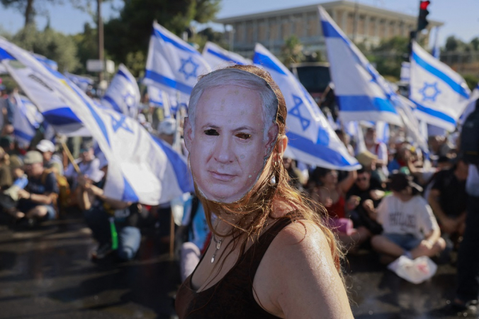 Um manifestante usando uma máscara representando o primeiro-ministro israelense Benjamin Netanyahu participa de uma manifestação para bloquear a entrada do Knesset, o parlamento de Israel