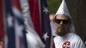 Um membro da Ku Klux Klan assiste durante uma manifestação, pedindo a proteção dos monumentos da Confederação do Sul, em Charlottesville