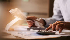 Economista usando calculadora ao passar por contas e impostos no escritório
