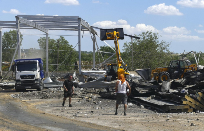 Homens locais trabalham no terminal de grãos danificado de uma empresa agrícola na região de Odesa, sul da Ucrânia