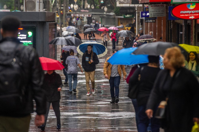 Pedestres enfrentam chuva na cidade de Porto Alegre (RS),