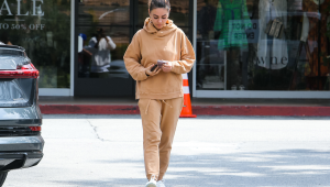 Mila Kunis usa um confortável moletom marrom e calça de moletom quando está fora de casa.