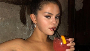 Selena Gomez com bebida vermelha na mão