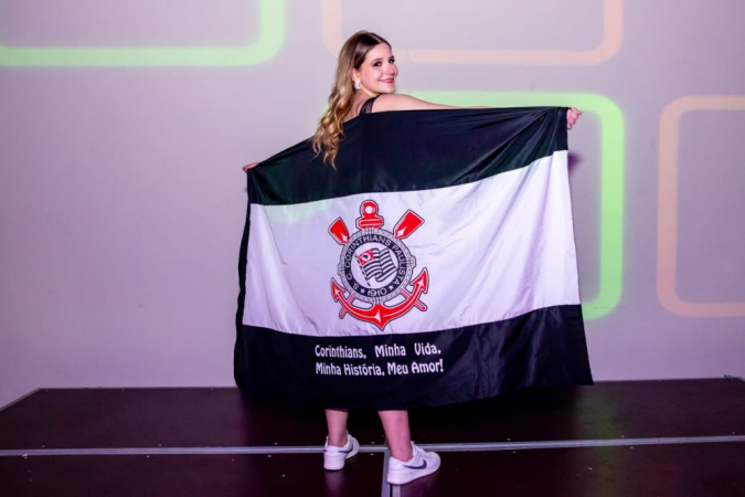 Adolescente enrolada na bandeira do Corinthians