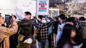 Um participante segura um cartaz durante o comício do Dia Internacional da Visibilidade dos Transgêneros no distrito de Shibuya, em Tóquio