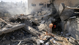 Palestinos procuram sobreviventes sob os escombros de um prédio desabado após um ataque israelense, em Khan Yunis, no sul da Faixa de Gaza