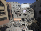 Palestinos inspecionam os danos a um edifício após ataques israelenses, em Khan Yunis, no sul da Faixa de Gaza