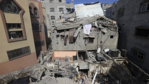 Palestinos inspecionam os danos a um edifício após ataques israelenses, em Khan Yunis, no sul da Faixa de Gaza