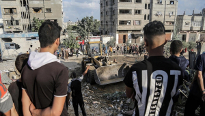 Palestinos procuram corpos e sobreviventes nos escombros de um edifício residencial destruído por um ataque aéreo israelense