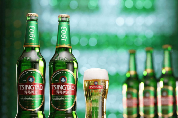 Garrafas de cerveja long neck da cor verde, além de um copo cheio, em foto de divulgação