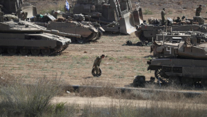Tropas israelenses com uma variedade de veículos militares, incluindo tanques de batalha 'Merkava', reúnem-se em um local de reunião não revelado ao longo da fronteira com Gaza