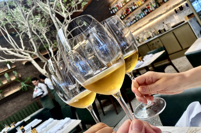 Brinde com três taças de vinho em mesa de restaurante