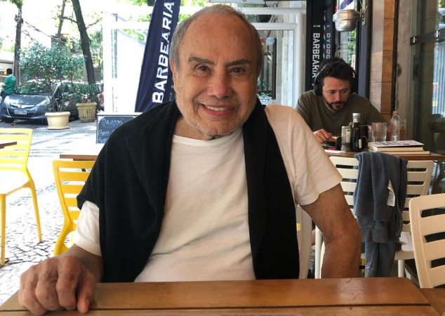 Ator Stenio Garcia em mesa externa de bar/restaurante