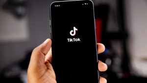 Mão segurando celular no TikTok