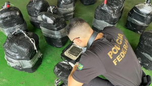 Agente da PF averiguando fardos encontrados em navio atracado no Porto de Vitória, no Espírito Santo