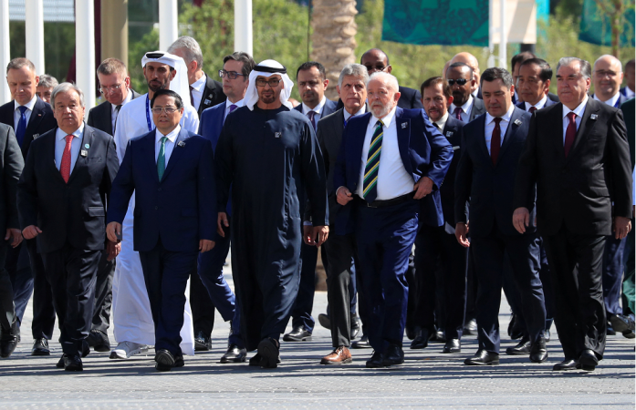 O presidente dos Emirados Árabes Unidos, Sheikh Mohamed bin Zayed Al Nahyan, caminha com o presidente do Brasil, Luiz Inácio Lula da Silva, ao lado de outros líderes e delegados mundiais