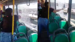 Mulher quebrando vidro de ônibus