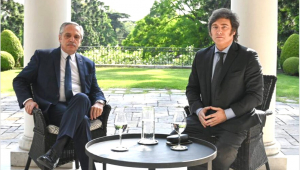 Alberto Fernández e Javier Milei sentados em uma mesa em jardim