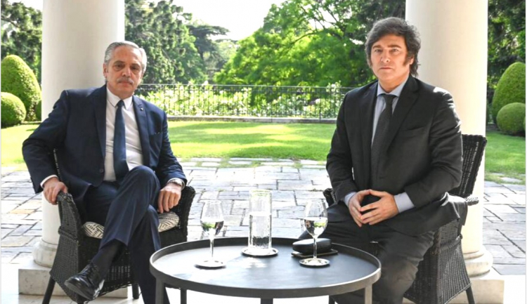 Alberto Fernández e Javier Milei sentados em uma mesa em jardim