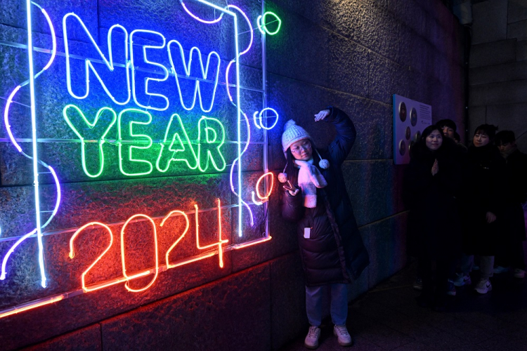 Uma mulher posa para uma foto em frente a um letreiro luminoso de 2024 antes de um evento de contagem regressiva para celebrar o Ano Novo no centro de Seul