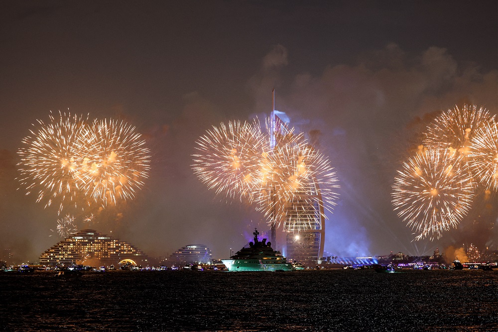 Fogos de artifício iluminam o céu perto da torre do hotel de luxo Burj al-Arab em Dubai