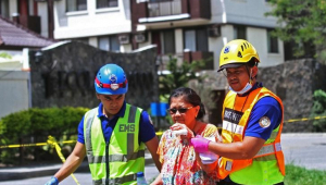 Imagen de archivo de operarios de emergencias ayudando a la evacuación de una residente de un condominio tras un sismo de magnitud 6,5 en Davao City, Mindanao, Filipinas.
