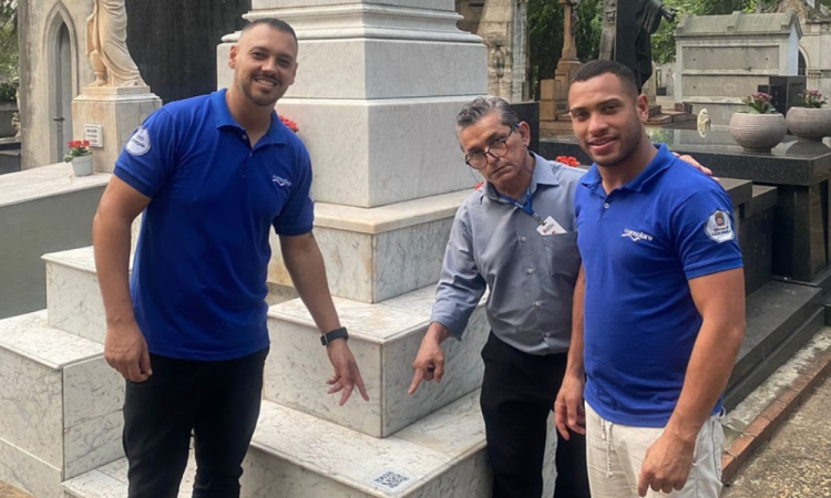 Equipe do cemitério da Consolação e Popó apontam para a e-lápide já instalada no túmulo de Dom Luiz Gastão de Orleans e Bragança