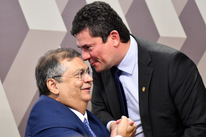 O ministro da Justiça, Flávio Dino, recebe os cumprimentos do senador, Sérgio Moro (União Brasil-PR), antes das perguntas da sabatina