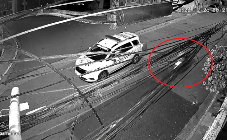 Moto (circulada em vermelho) com o pai e bebê passa por carro de polícia, de onde agente efetuou disparo