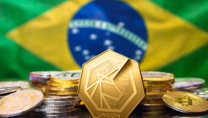 Moedas, com destaque parta o Bitcoin, e bandeira do Brasil atrás