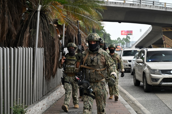 Soldados equatorianos patrulham o lado de fora das instalações do canal de televisão TC