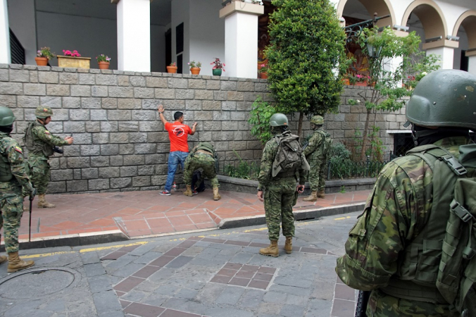 Soldados equatorianos revistam um homem durante uma patrulha nas ruas de Cuenca