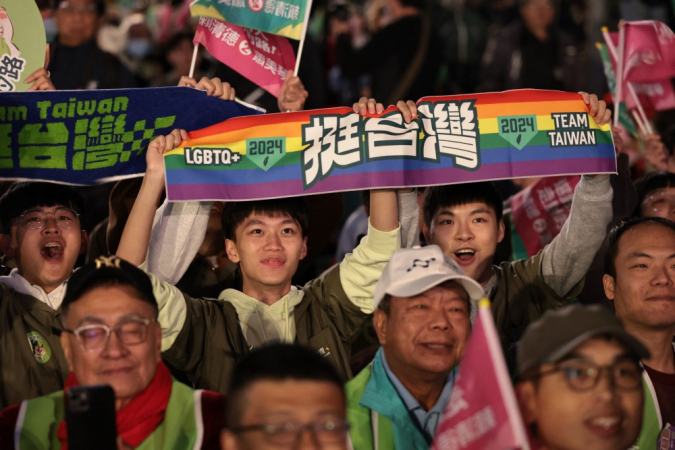 Apoiadores do vice-presidente de Taiwan e candidato presidencial do Partido Democrático Progressista (DPP), Lai Ching-te, seguram cartazes enquanto aguardam os resultados da eleição presidencial fora da sede do partido