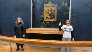 dois ativistas ambientais do coletivo apelidado de "Riposte Alimentaire" (Retaliação Alimentar) gesticulando em frente à pintura "Mona Lisa"