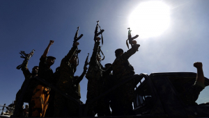 Combatentes Houthi recém-recrutados entoam slogans enquanto dirigem um veículo militar