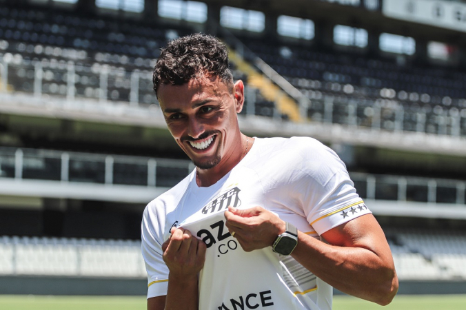 O volante Diego Pituca beija o escudo do Santos na Vila Belmiro