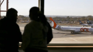 Pasageiros observam aviões na pista