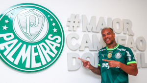 Caio Paulista com a camisa do Palmeiras, apontando para o símbolo do clube