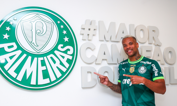 Caio Paulista com a camisa do Palmeiras, apontando para o símbolo do clube