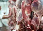 Carne vermelha fresca, e trabalhador de talho trabalhando em segundo plano