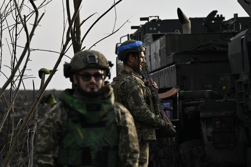 Militares ucranianos das Forças de Assalto Aéreo se preparam para disparar um obuseiro autopropulsado Caesar 8x8 de 155 mm com rodas em uma linha de frente em um local não revelado, no sul da Ucrânia