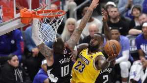 O atacante do Los Angeles Lakers, LeBron James (R), chuta a bola contra o pivô do Los Angeles Clippers, Daniel Theis (L), durante o segundo tempo do jogo de basquete da NBA