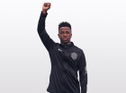 Vini Jr com a mão direita levantada com o punho cerrado
