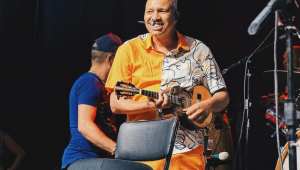 Cantor do Molejo tocando cavaquinho no palco