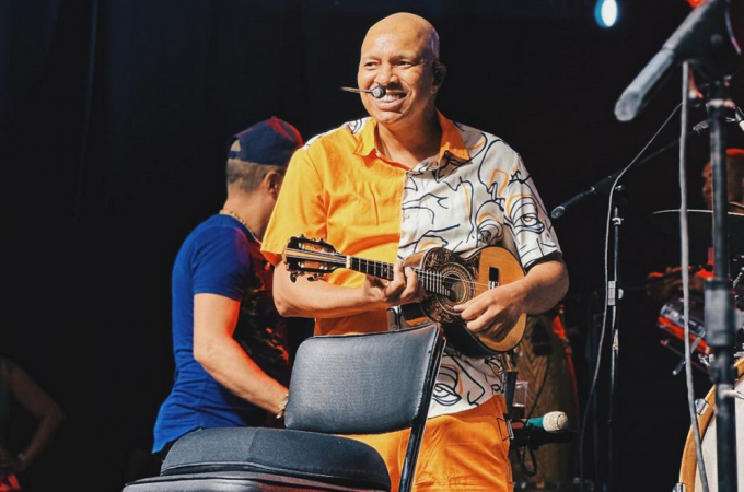 Cantor do Molejo tocando cavaquinho no palco