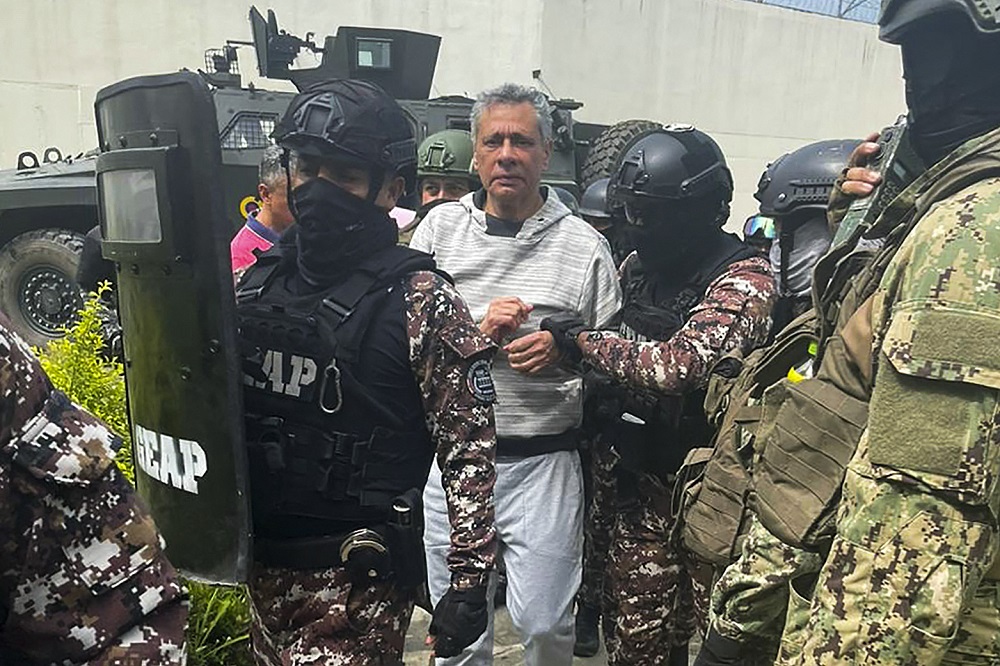 o ex-vice-presidente equatoriano Jorge Glas sendo escoltado por membros do Grupo de Ação Penitenciária Especial (GEAP) durante sua chegada à prisão de segurança máxima La Roca, em Guayaquil